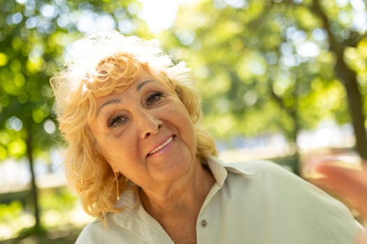 Happy mature woman with blonde hair enjoying sunny day in nature