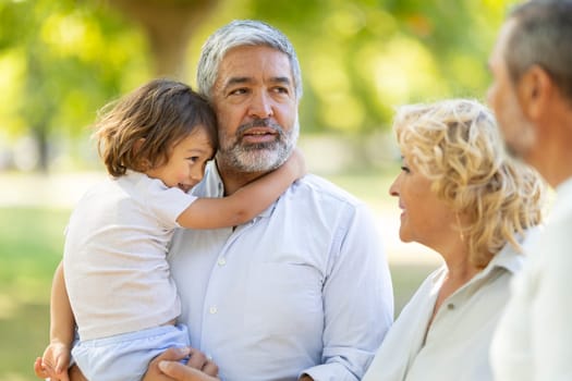 Multi-generation family is spending time together at the park on a sunny day