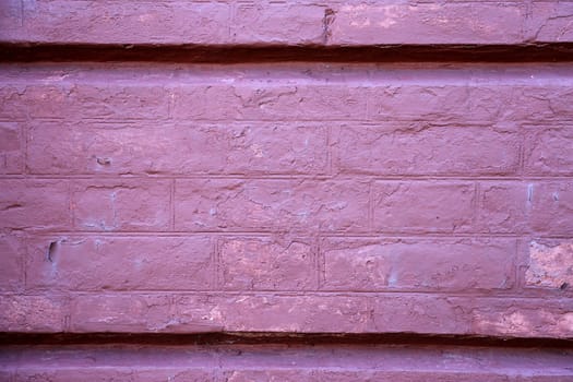 Fragment of the facade of a brick wall of an old red building.