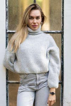 Beautiful young woman posing wearing a white sweater and jeans