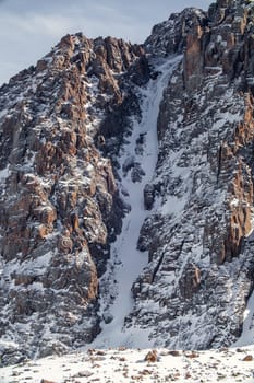 Picturesque vertical background of snow capped rock in the mountains of Central Asia Tien Shan range in Kazakhstan near Almaty.
