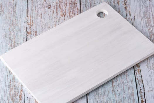 Empty cutting board on blue wooden background.
