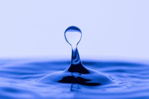 A pstudio image of a water drop in rippled water.