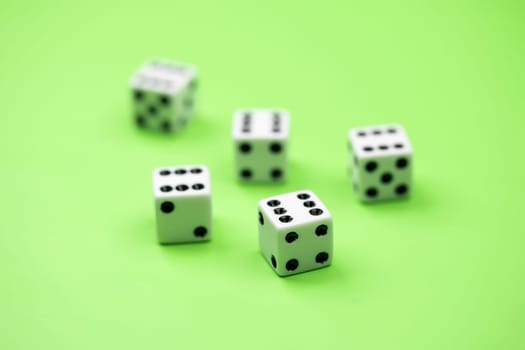A conceptual photo of 5 dice on green with the number six showing.