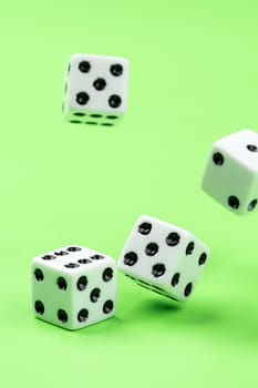 A conceptual photo of dice being rolled on a green table.