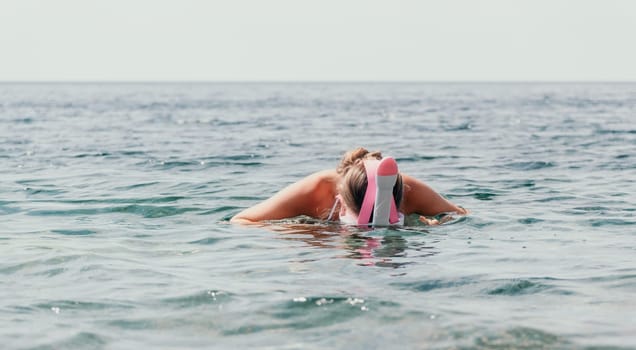 Young happy woman in white bikini put pink snorkeling mask on beach before swimming. girl having fun relaxing on beautiful beach. Beach lifestyle