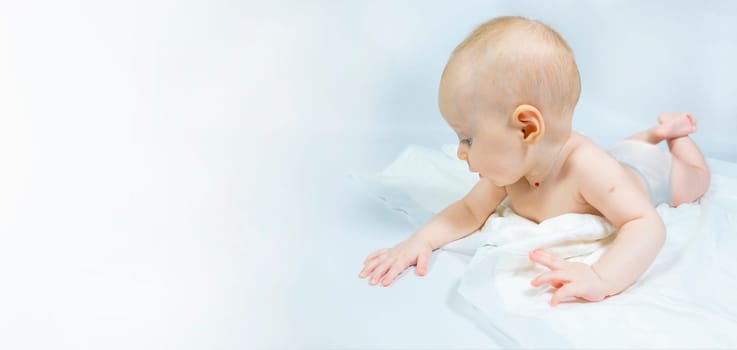 a baby with a hemangioma on his neck lies on a white background. banner with a copy space. profile of a little bald baby girl. the kid looks to the side