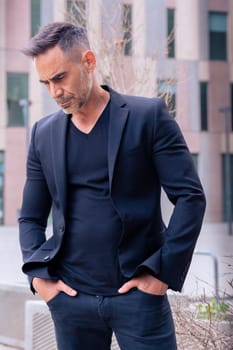 Caucasian businessman looking angry at the ground in a suit standing in an outdoor workspace. Front view of a young lawyer with a pensive expression staring
