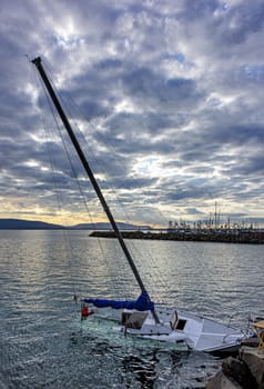 White yacht sinking in Pacific Ocean bay.