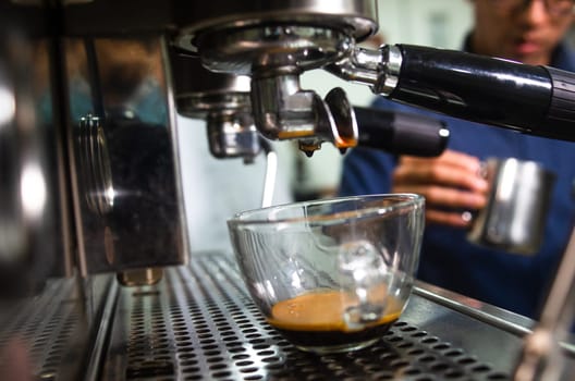 Professional espresso machine pouring coffee into a glass