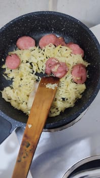 pasta with sausage in a frying pan, dinner lunch food cooking. High quality photo