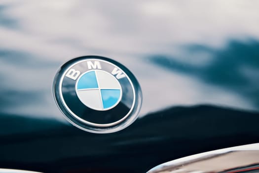 A detailed view of the BMW emblem adorning the car's hood. BISHKEK, KYRGYZ REPUBLIC - 19 AUGUST 2021