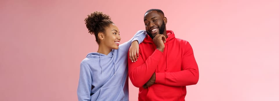 Two best friends having fun man smiling woman leaning his shoulder talking laughing joking like spending time together, standing pink background chit-chat confident relaxed poses. Copy space