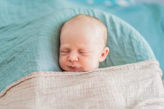 The baby is sleeping peacefully in his cozy nest. Newborn photo session captures the serene innocence and warmth of early moments.