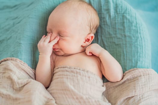 The baby is sleeping peacefully in his cozy nest. Newborn photo session captures the serene innocence and warmth of early moments.