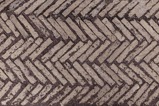 Old antique sidewalk made of decorative stone tiles.