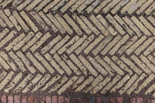 Old antique sidewalk made of decorative stone tiles.