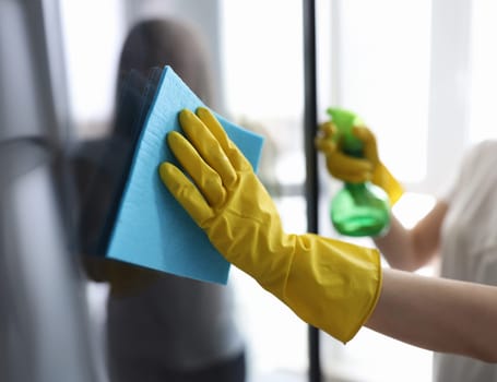 Man washing window in protective gloves closeup. Cleaning of apartments concept