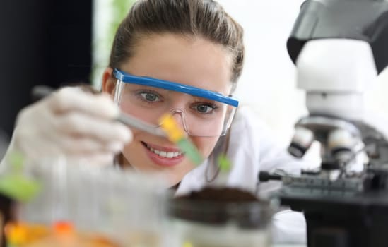 Female researcher with glasses conducts soil research. Soil analysis concept