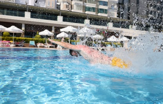 Man is engaged in swimming in the pool. All inclusive in resort hotels concept