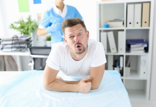 Surprised man undergoes medical examination by proctologist. Bowel disease in man concept