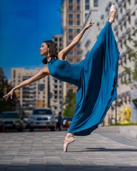 Beautiful Asian ballerina dancing outdoors. Urban landscape