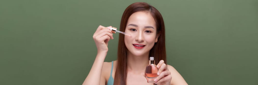 Crop young female applying serum on face, banner