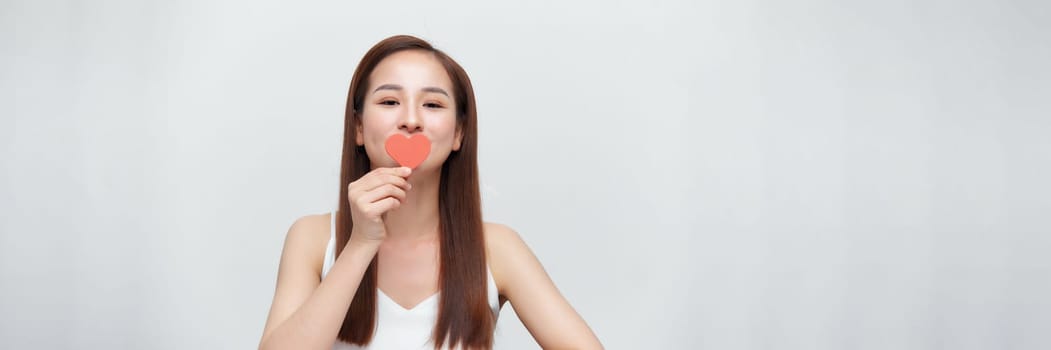 Attractive asian woman covering eyes with small red hearts, panorama