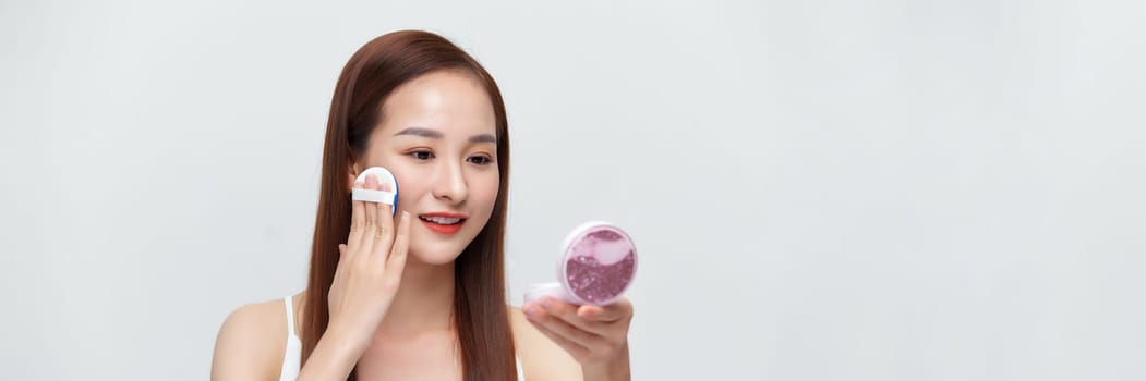 Glamorous beautiful female applying cushion powder for facial makeup concept on banner
