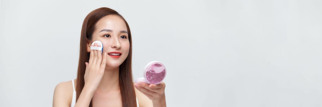Banner of flawless perfect cosmetic skin woman put powder puff on her face in isolated background.