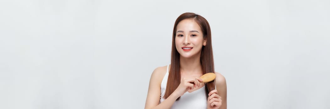 Pretty asian woman is combing her hair isolated on the white background. panorama