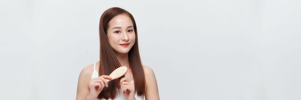 Banner of young woman brushing her hair and smiling isolated over white background