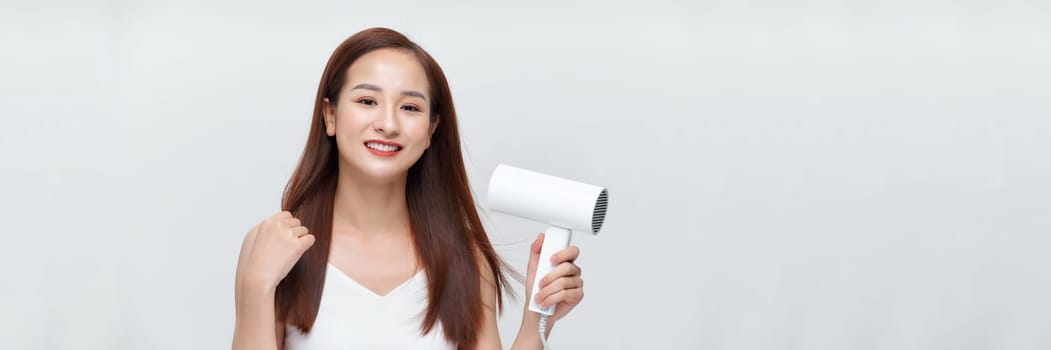 Banner of beautiful smiling girl with long straight hair using hairdryer. 