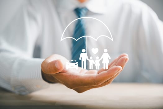 Championing family security, Businessman protective gesture alongside young family silhouette. Health and house insurance icons symbolize safety, reinforcing family life insurance concepts.