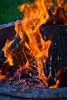 Image of Close up of three logs with orange and yellow flames in fire pit