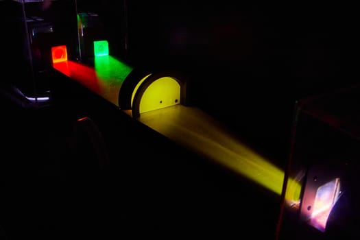 Image of Light experiment with green and red light beams meeting a yellow block with science for the win