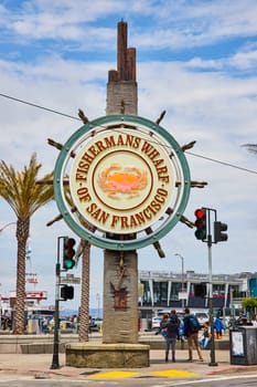 Image of Fishermans Wharf of San Fransisco sign with crab on it with pedestrians walking