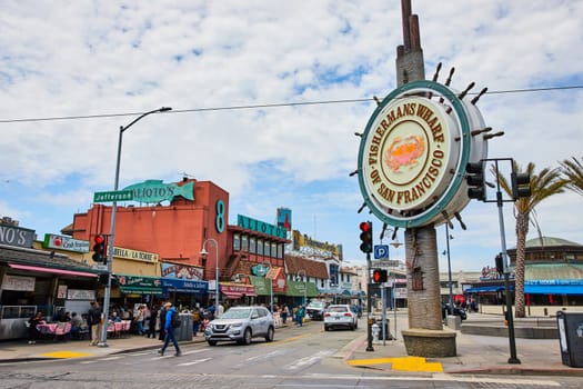 Image of Fishermans Wharf sign with crab on it with shops along street