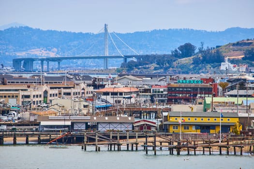 Image of Piers and docks with boats and Oakland Bay Bridge in background