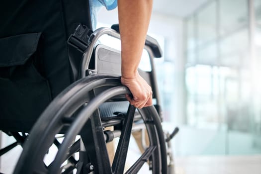 Hand, rehabilitation and person in a wheelchair at a hospital for medical support, transportation and mobility. Closeup, help and a patient with a disability in a chair at a clinic for recovery.