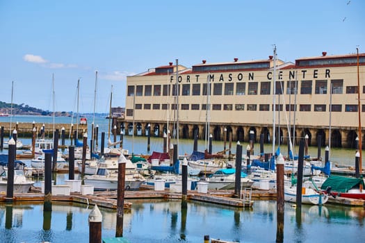 Image of Fort Mason Center with boats tied to docks on calm summer morning