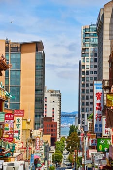 Image of Chinatown in San Francisco with shop and restaurants signs along road leading to the bay