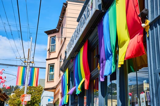 Image of Rainbow banners on Vico Cavone building with blue sky in San Francisco California