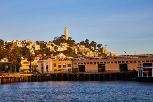 Image of San Francisco Bay view looking at shoreline and Coit Tower on hill near sunset