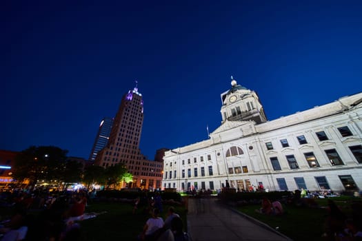 Image of Crowd of people on Allen County Courthouse lawn at night with illuminated buildings
