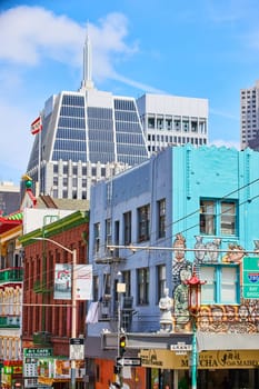 Image of Chinatown mural on building wall with signs and blue sky with white clouds