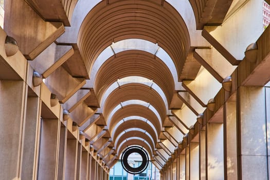 Image of Symmetrical and optical illusion ceiling with curving openings with tunnel view to black opening