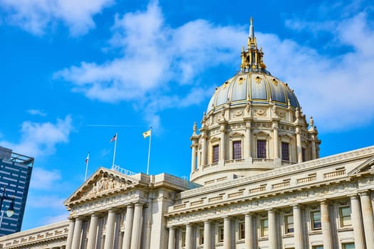 Image of City hall with flags on top of pointed roof and blue and gold dome under gorgeous summer sky