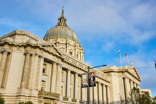 Image of View of elaborate pillared entrance to San Francisco City Hall with flags flapping in the wind