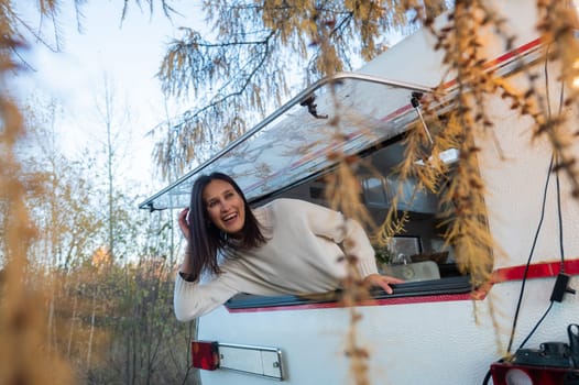 Caucasian woman peeking out of camper window